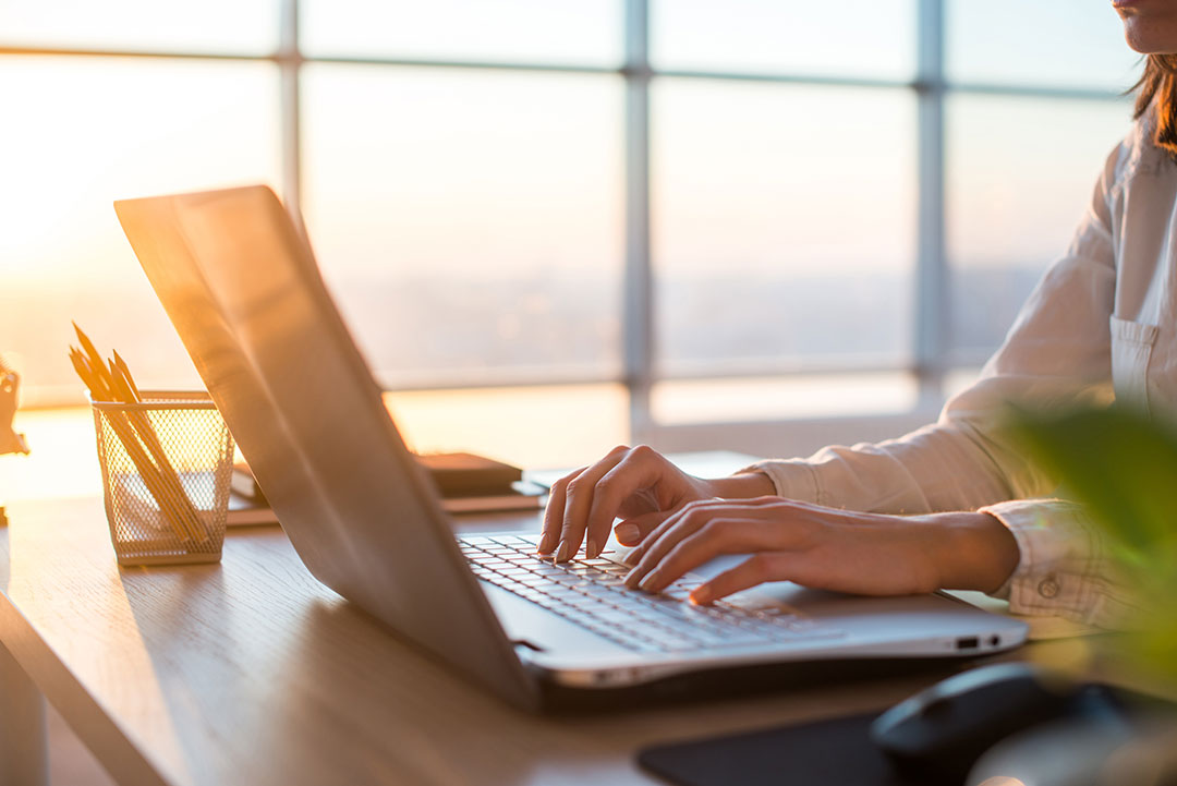 Image of a person typing on their laptop