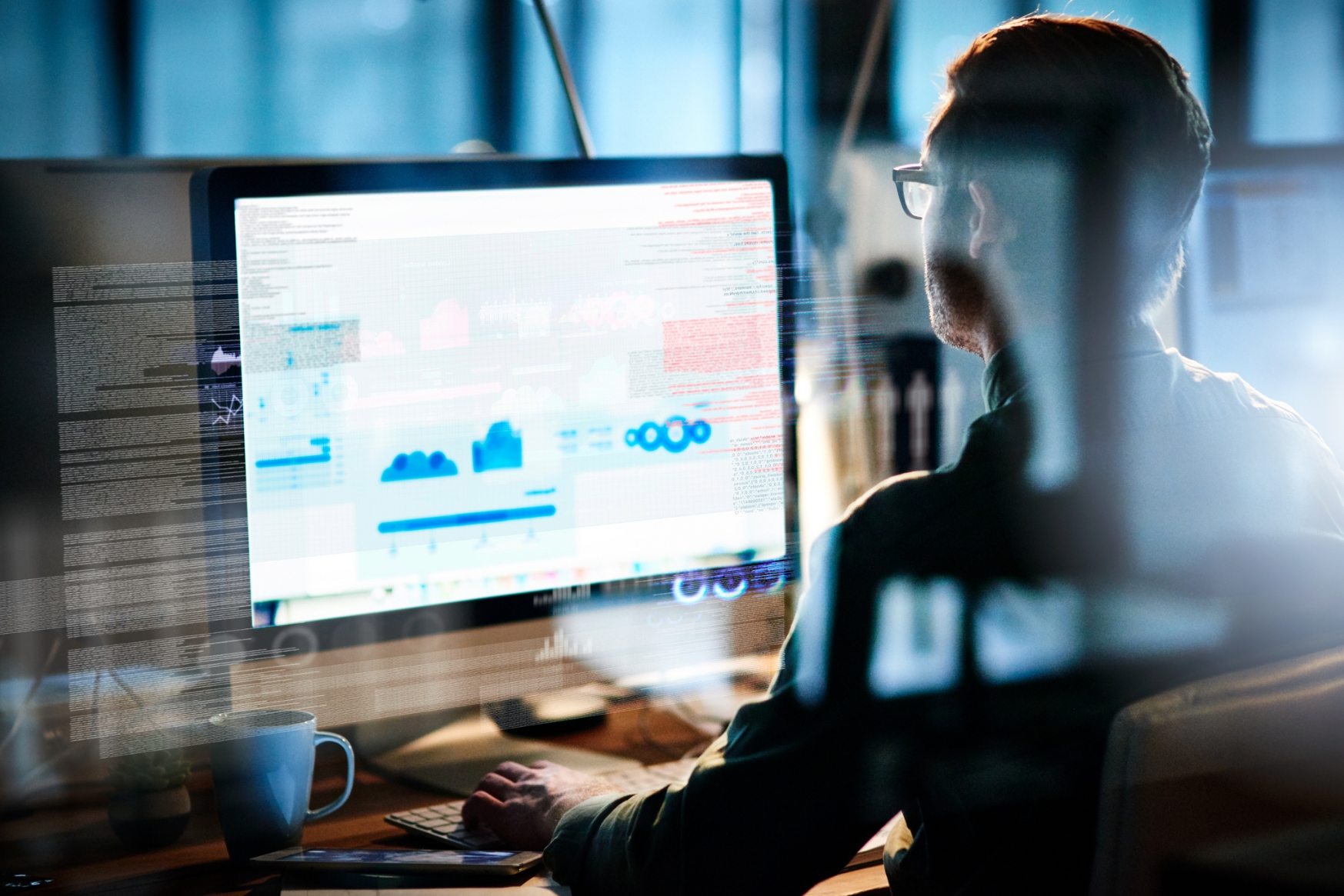 Man using a desktop computer with data analytics on the screen