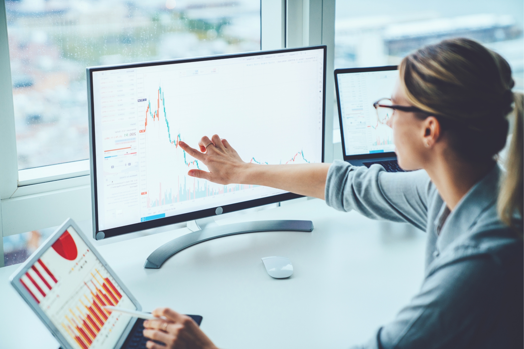 Woman pointing at data on desktop computer