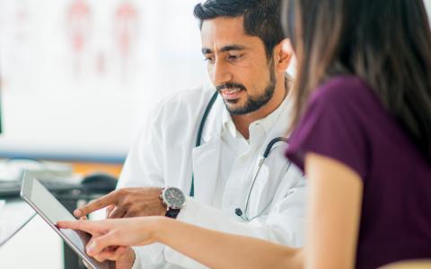 Image of a doctor with a patient viewing a tablet