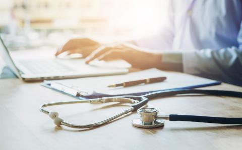 Image of a doctor typing on a laptop